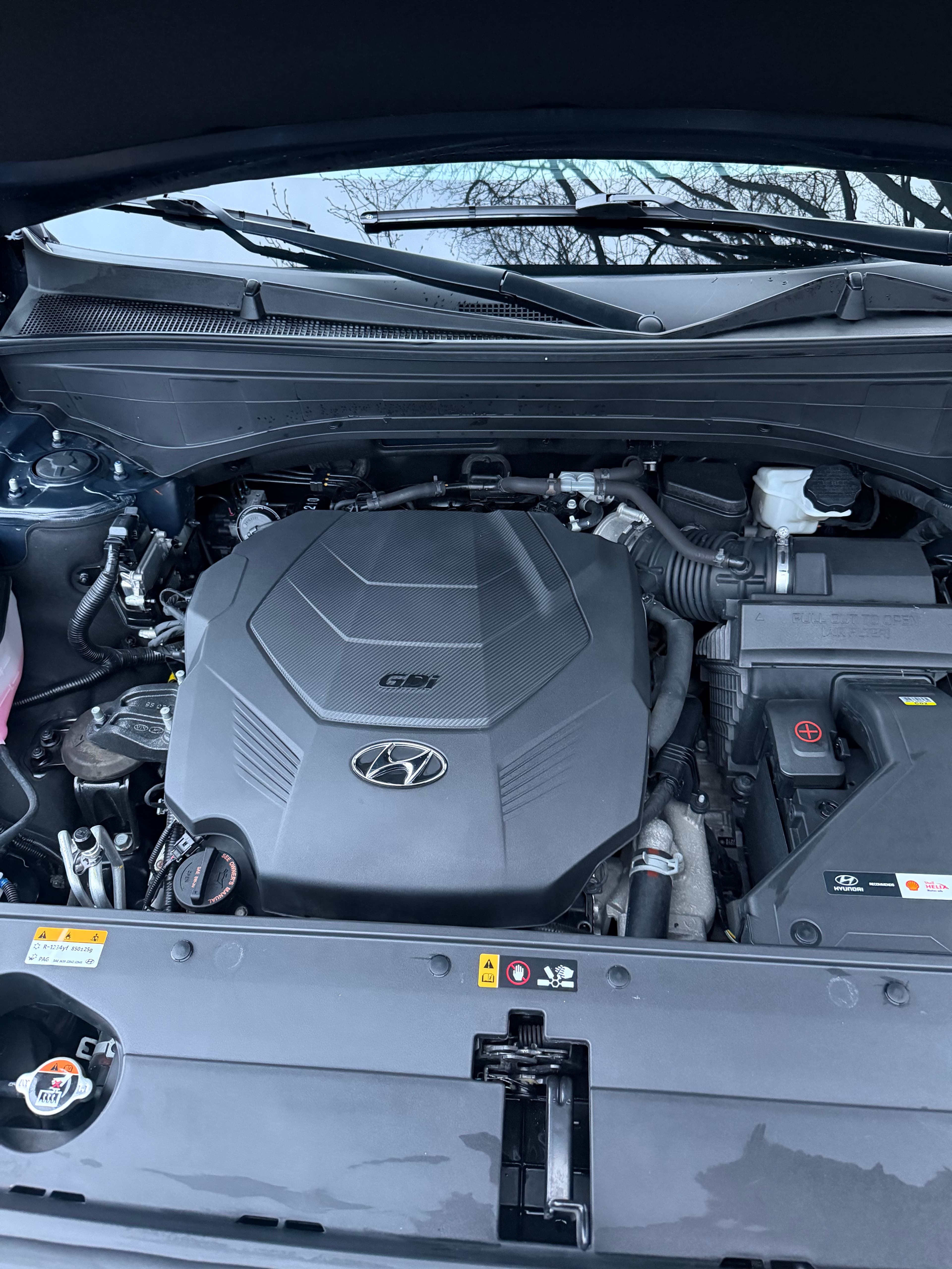 Overhead view of a Hyundai car engine bay featuring a black GDI engine cover.