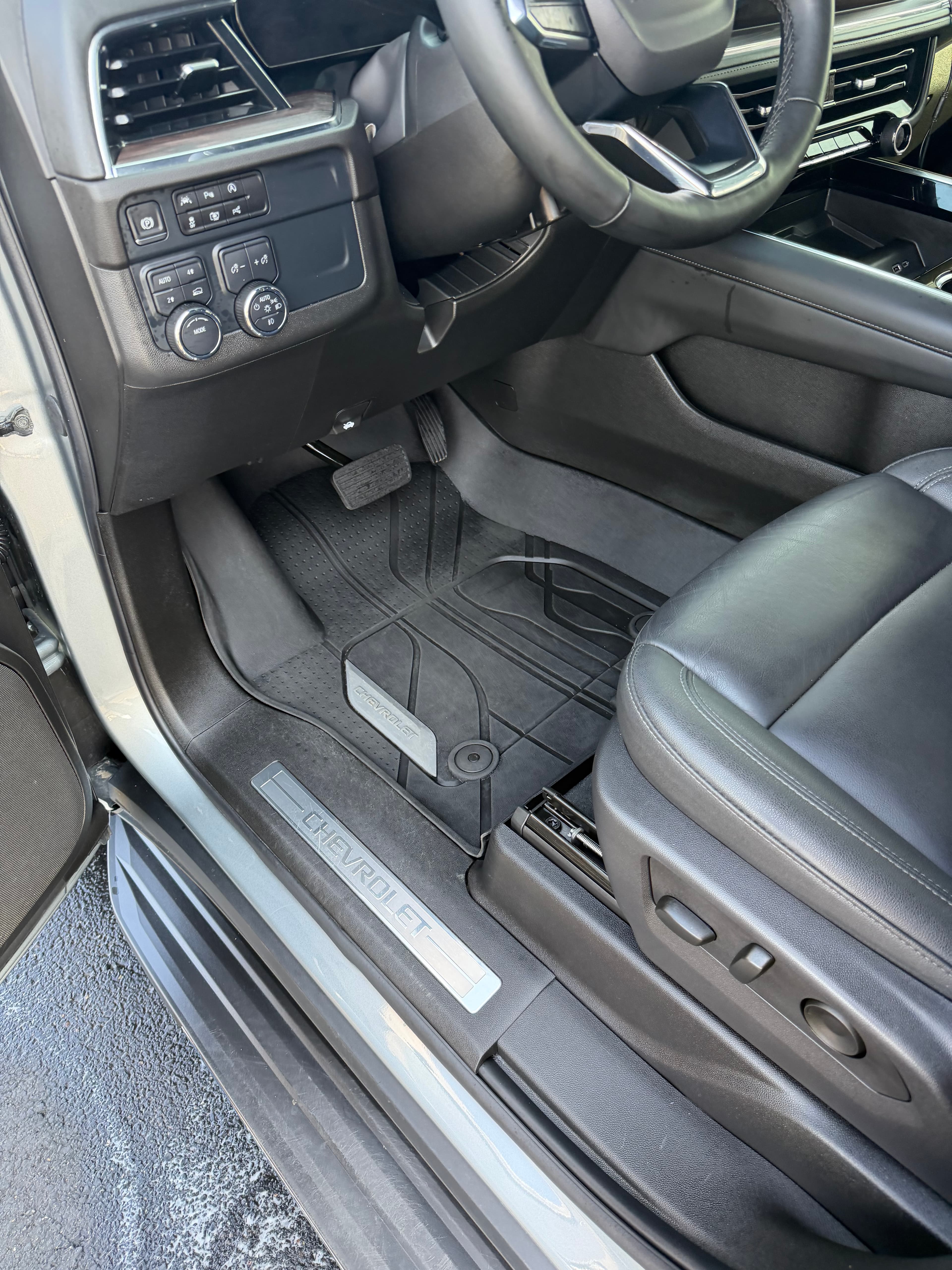 Chevrolet driver's side interior featuring black leather seat, steering wheel, and branded floor mats.
